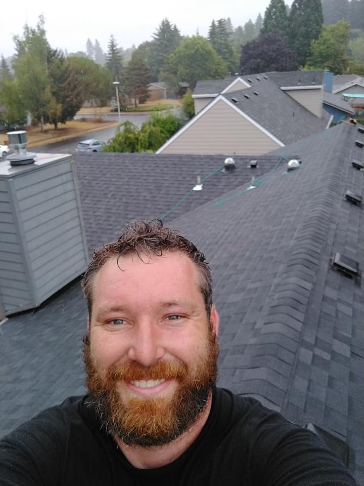 Owner of the company, David Jackson, smiling on top of a roof he just replaced.